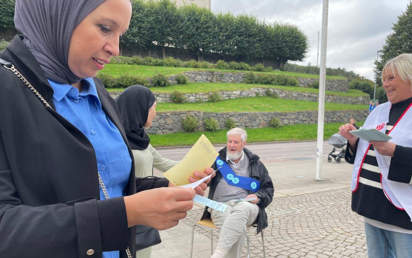 Meryem Mdivi får en valsedel i handen utanför kommunhuset. 
