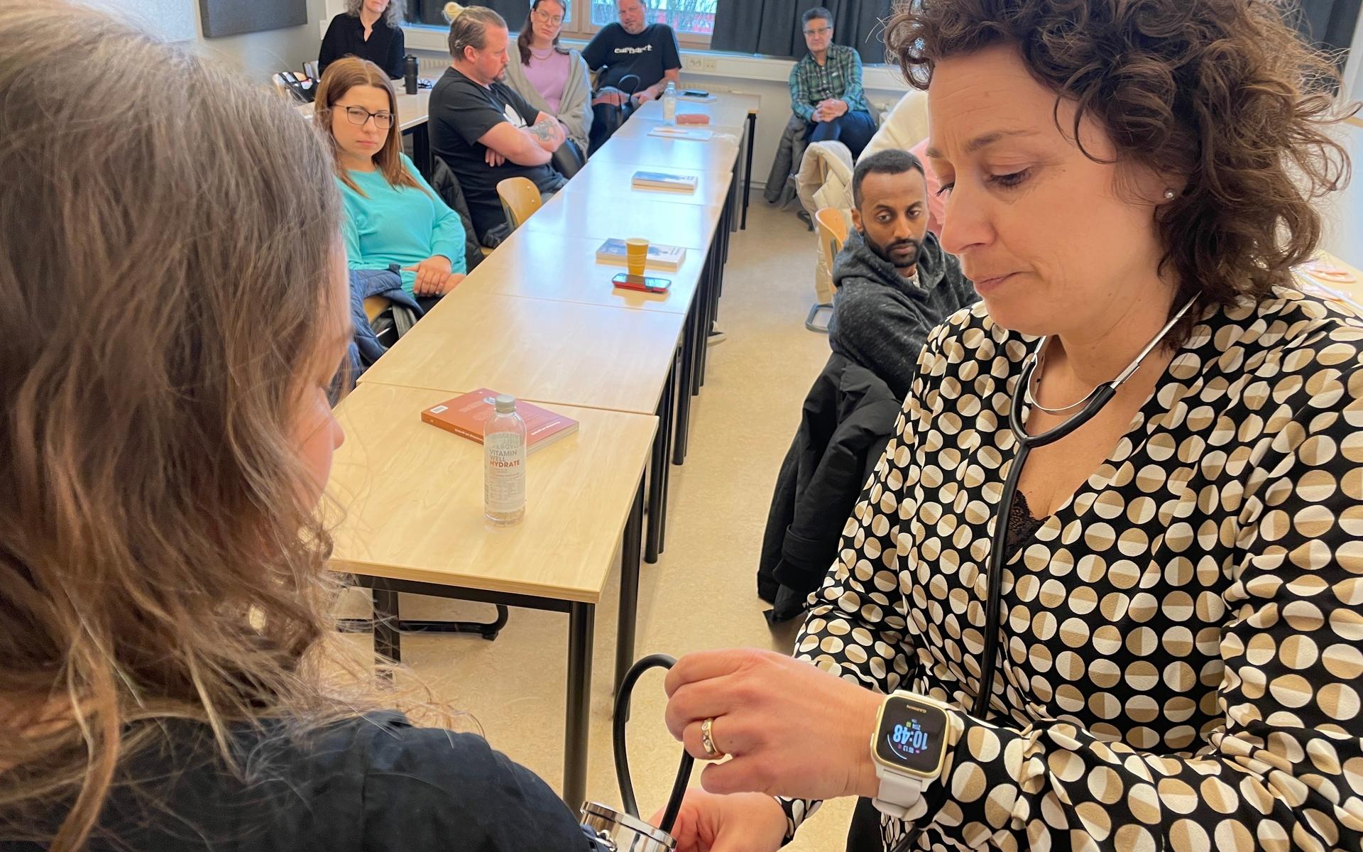 I klassen samsas elever från tre olika kommuner. Här visar läraren Karin Henriksson hur man ska ta blodtrycket inför hela klassen.