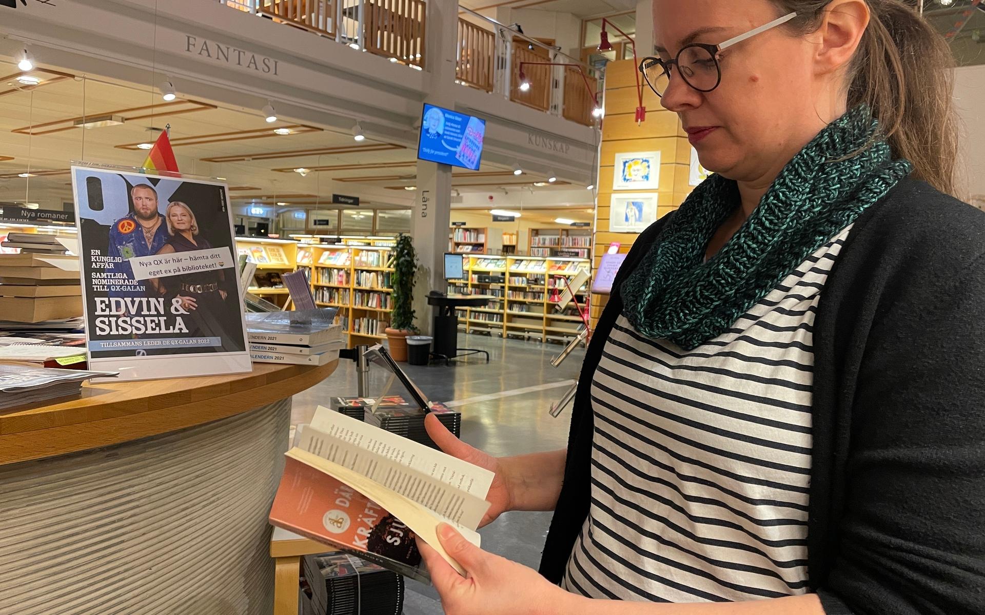 Karoline Thyne visar den mest utlånade boken på biblioteket ”Där kräftorna sjunger” av Delia Owens